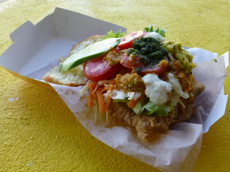 Bake and shark piled with salad and sauces in a takeaway box