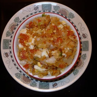 Saltfish buljol with tomato and onion on a decorated plate