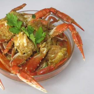 Pieces of crab in a thick curry sauce, topped with herbs