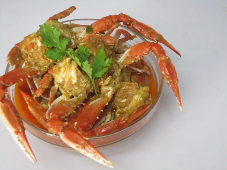 Pieces of crab in a thick curry sauce, topped with herbs