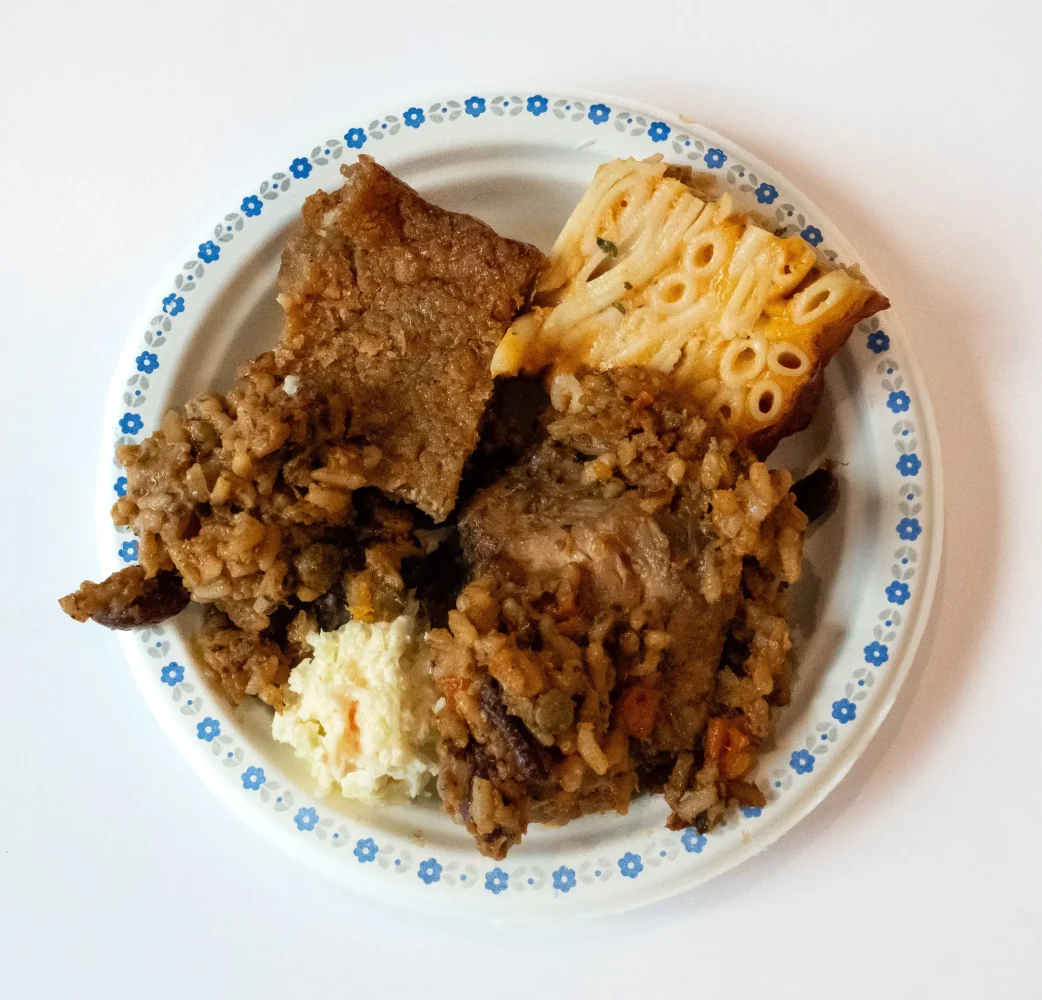A Trinidad Sunday plate: pelau, coleslaw, a slice of macaroni pie and cassava pone