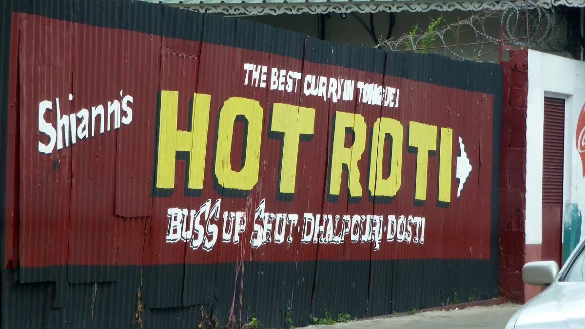A hand-painted Hot Roti sign in Port of Spain advertising buss up shut and dhalpuri