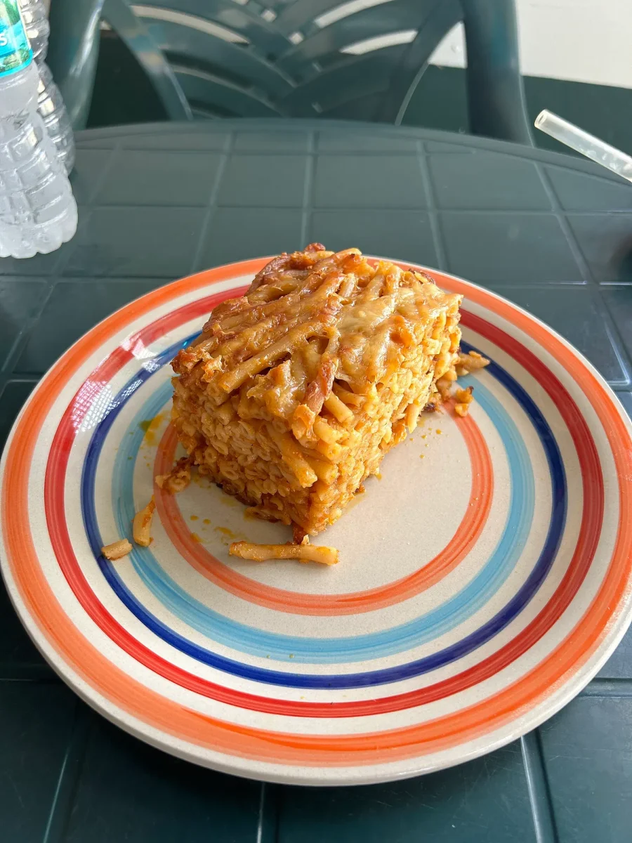 A slice of baked macaroni pie on a striped plate