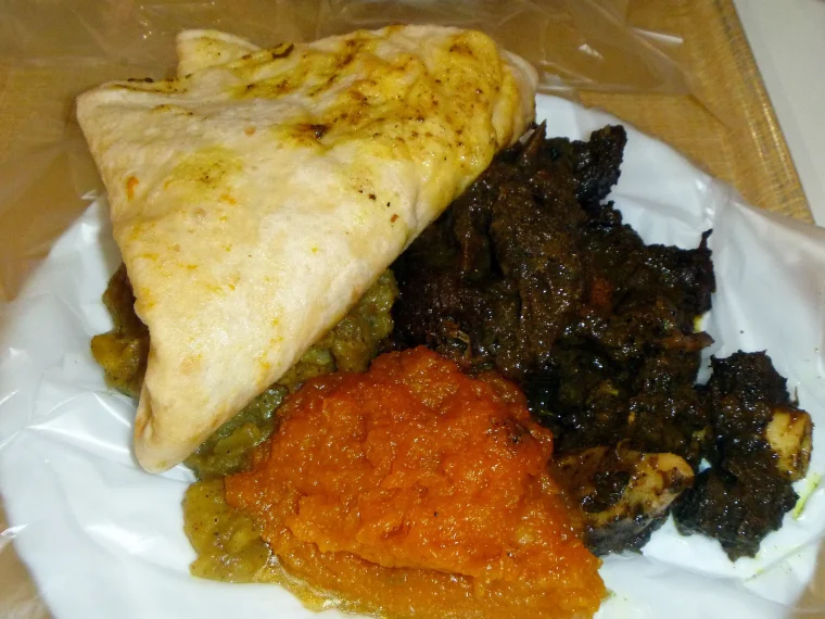 Dhalpuri roti with curry goat, pumpkin and channa and potato