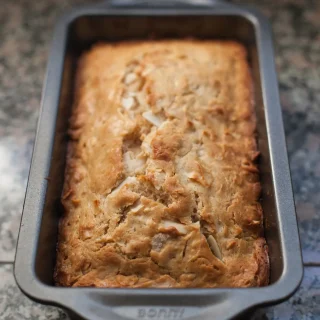 A loaf of coconut bread in its baking tin