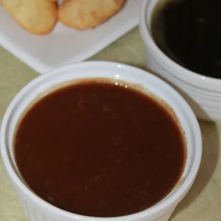 A bowl of dark, glossy tamarind chutney
